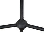 Close-up of chandelier’s central black metal hub where arms meet