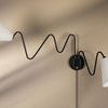 Black Onda sconce with two white shades installed side by side on beige wall