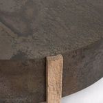 Close-up detail of iron drum edge with vertical oak leg showing wood grain
