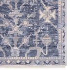 close-up of rug corner highlighting intricate blue and gray border details with subtle floral motifs