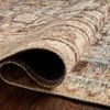 Close view of Loren Rug rolled to reveal woven polyester back and delicate stitched edge finish
