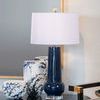 Detailed view of Boulevardier Bar Cart with blue table lamp and ceramic vases on top, showing cart handle and gold accents