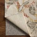 Corner flipped up to reveal underside and rug pad beneath on hardwood surface