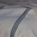 close-up of woven texture and fine black stripes on cream cotton throw fabric