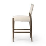 Side profile highlighting gentle curve of back cushion and wood frame details