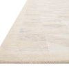 Close-up angled view showing the rug's woven texture and soft color gradation with slightly raised border