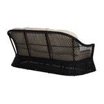 Oblique rear angle of sofa showing curved back with lattice weave and cushion placement