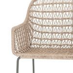 Front of stool showing white wicker seat and back with slim bronzed iron legs