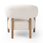 Side view displaying slender back oak leg contrast with ivory seat and back cushions