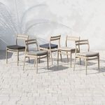Six Atherton wooden chairs with assorted neutral-color cushions arranged in irregular cluster on pale stone patio