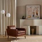 Roberts chair shown in living room setting with curtains, carpet, floor lamp, and modern framed art.