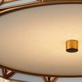 Close-up of white milk glass diffuser and antique brass knob at flush mount center