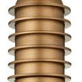 Detailed view of the ribbed, layered cylindrical stem in antique brass finish