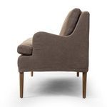 Profile side view highlighting curved armrest and slim wooden legs in amber oak