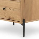 Close-up showing black metal leg with textured matte finish on nightstand corner