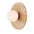 Apricity Wall Sconce angled to the side with illumination casting warm glow on travertine disc
