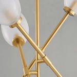 Close-up of aged brass finish on multiple intersecting arms with frosted glass shades