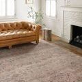 Traditional rug styled in bright living room with tan leather sofa and white fireplace