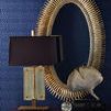 Close-up of Lucius Mirror frame with antique silver leaf finish and textured detail by lamp and décor