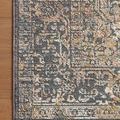 Top-down view of the rug corner on hardwood floor highlighting edge stitching and texture