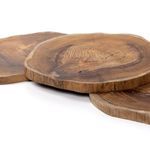 Side view of three stacked round teak trays highlighting thickness and organic edges