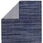 Back side flipped corner reveals striped pattern in cream and navy on rug reverse
