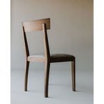 Leone Dining Chair styled seated in a light, minimalist room with neutral walls and natural light