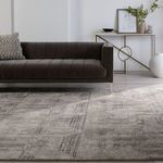 Living room scene with dark gray sofa positioned along edge of the geometric gray rug