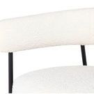 Close-up of chair’s textured white boucle upholstery on padded seat and backrest