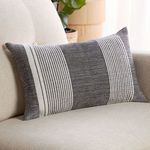 Pillow styled on beige sofa with natural light and plant in background