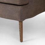 Close-up of tapered solid oak leg with amber oak finish under banquette frame