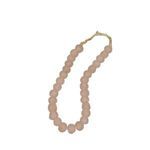 Single strand of blush pink sea glass beads displayed vertically with visible twine string