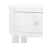 Close-up of drawer front with round brass pull and linen textured finish
