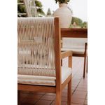 Close-up from back showing white woven wicker details and outdoor patio background