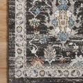 Top-down view of rug corner on light hardwood floor, highlighting patterned border and color contrast