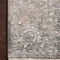 Close-up of rug corner on dark wood floor highlighting intricate pattern and silky texture