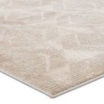 Close-up corner view showing textured geometric pattern and plush pile in light gray and beige tones
