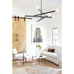 Sanya Metal Vase styled with green leaves on a white round coffee table in bright eclectic living room with wood barn doors