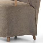 Close-up focus on slipcover draping and wood leg base of Brently Dining Chair