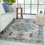Styled room scene featuring rug placed under sofa and decorative stool near large window