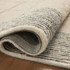 Edge of Francis rug rolled back to reveal durable gray woven backing material