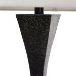 Close-up of electrical cord attached to textured tapered metal base with plug visible
