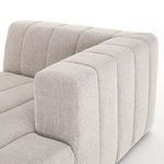 Detail of vertical channeling on the rounded armrest of sandstone fabric