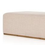 Lifestyle setting with ottoman as coffee table, beige sofa, throw blanket, and pillow