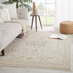 Living room setting with window light, beige rug on floor, neutral sofa, and cozy pouf