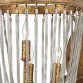 Close-up on two candle-style bulbs and detailed metal chains against gold circular frame