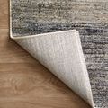 Corner fold showing rug's woven backing and layered pile in muted gold, grey, and cream