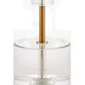 Close-up of Deville Table Lamp’s clear optic crystal disc base and slim metal stem in an antique brass finish