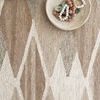 Close-up showing the textured weave and natural fiber blend with decorative bowl and beads on the rug