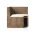 Three-quarter front angle highlighting woven rattan and plush cushion